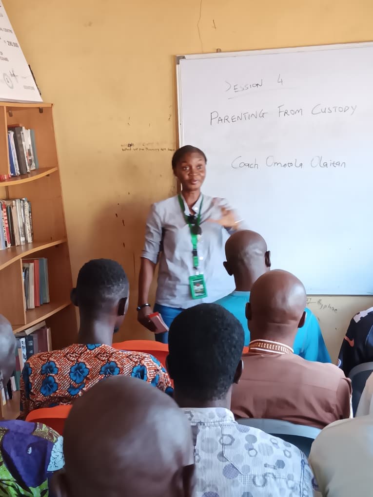 Facilitator leading a parenting session in a custodial classroom